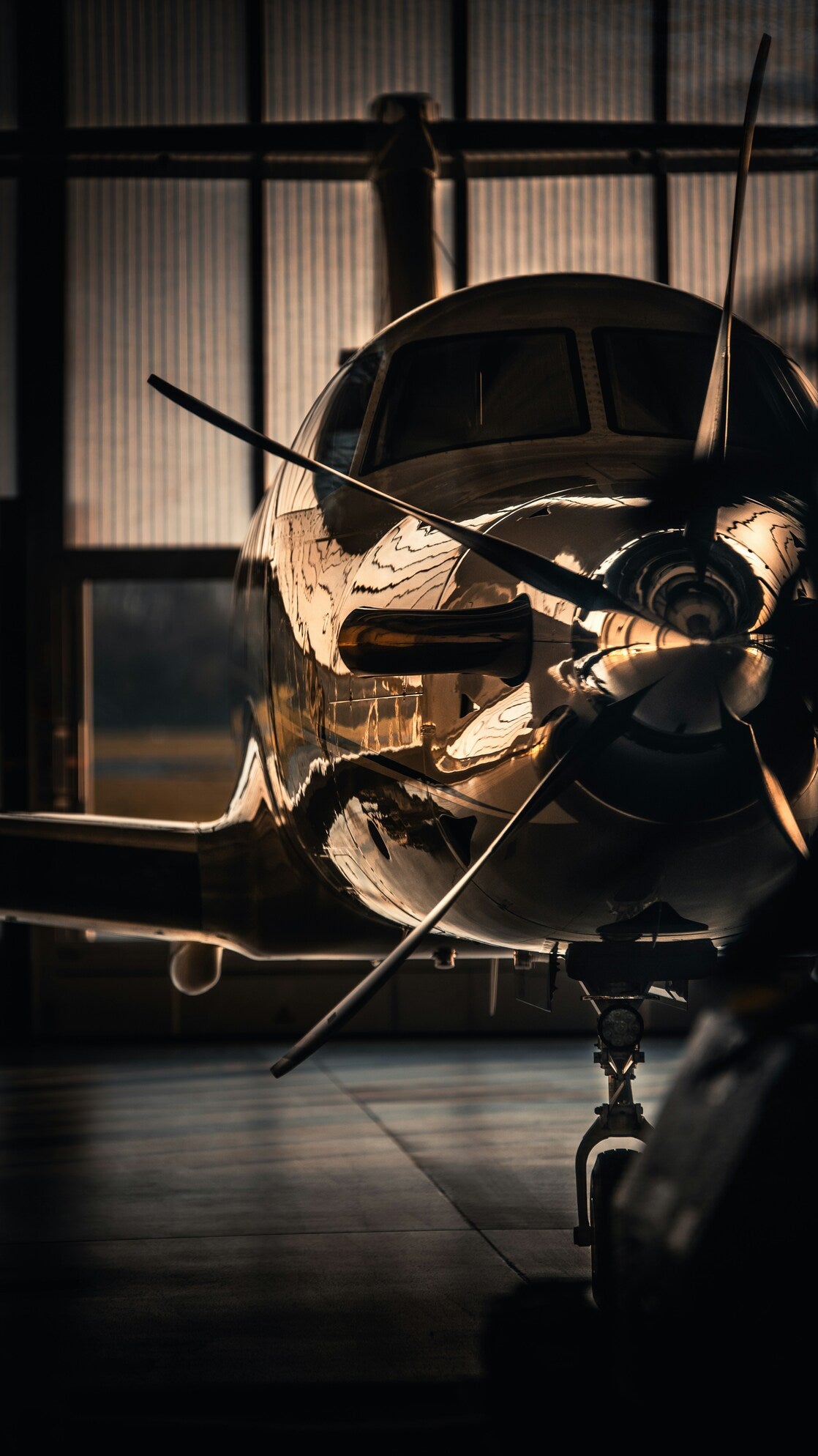 Hangar Propeller Nocturne - Aircraft propeller and fuselage in dark hangar light. Museum-grade framed artwork by Veriando Studio.