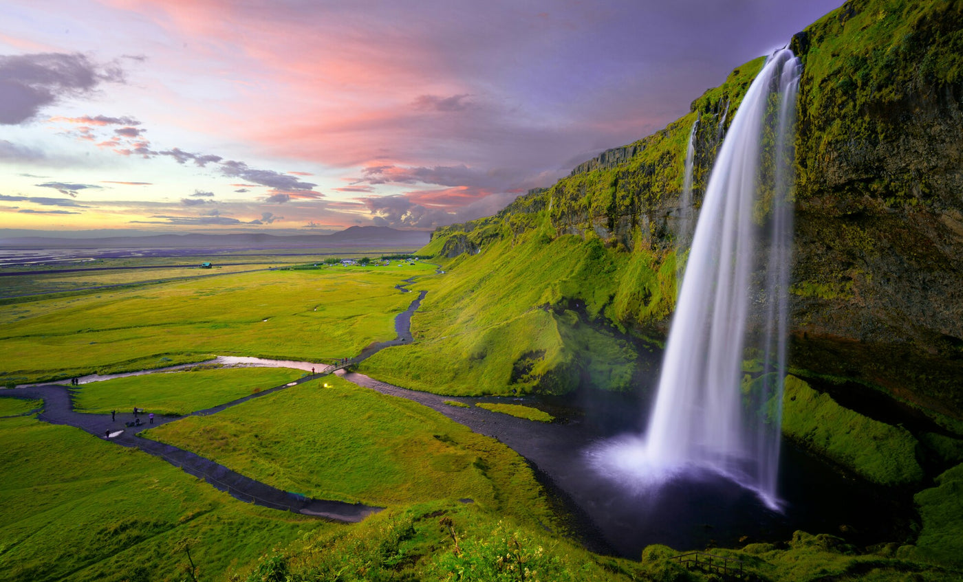Icelandic Waterfall Plain - Tall waterfall falling over a green plain at sunset. Museum-grade framed artwork by Veriando Studio.