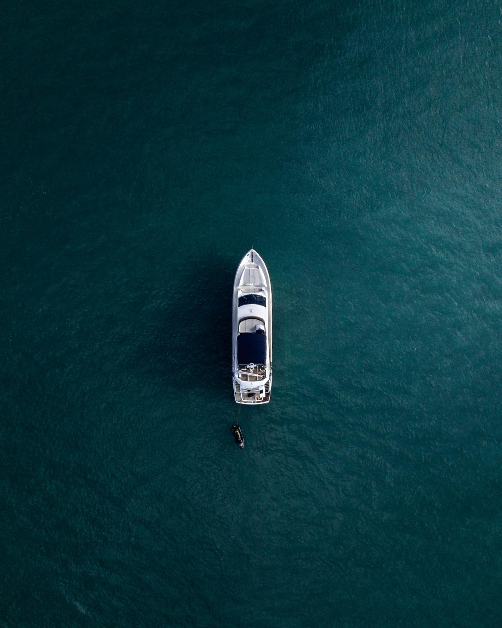 Lone Boat in Teal Water - Single small boat centered in deep teal water. Museum-grade framed artwork by Veriando Studio.