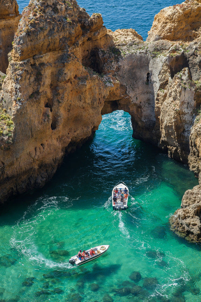 Turquoise Cove Descent - Turquoise cliff cove with small boats and swimmers. Museum-grade framed artwork by Veriando Studio.