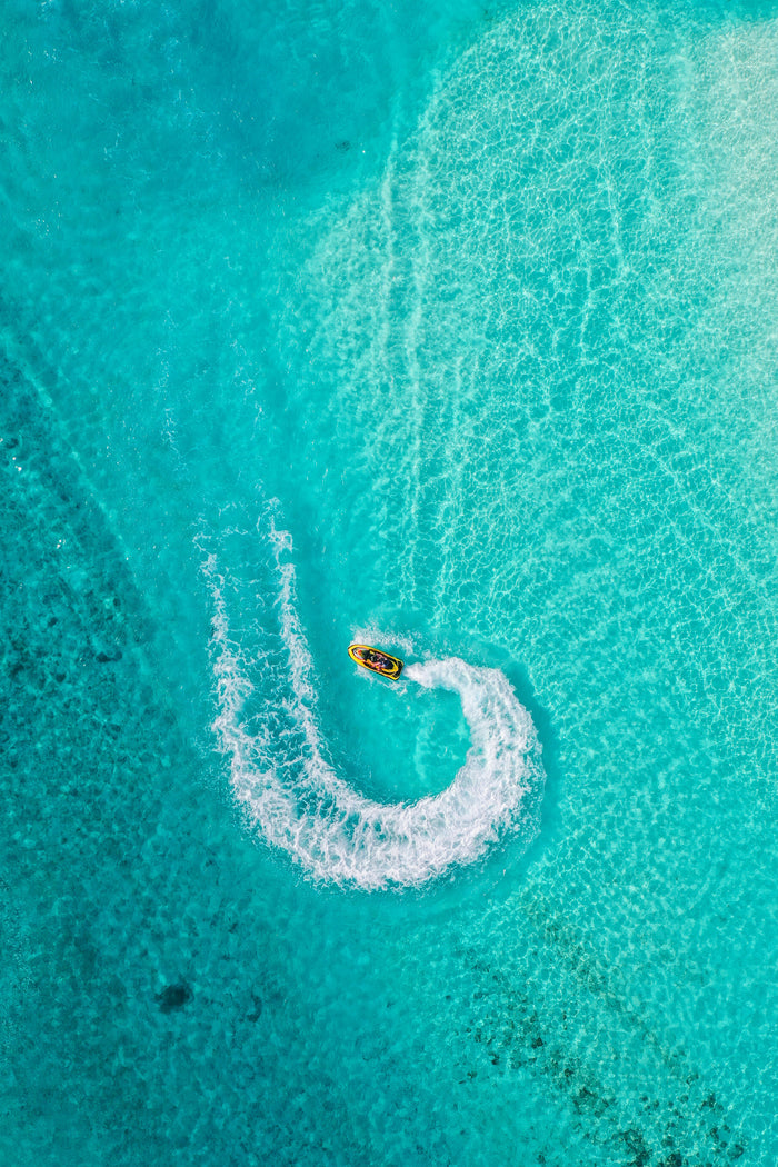 Turquoise Wake - Small boat drawing a white curve in turquoise water. Museum-grade framed artwork by Veriando Studio.