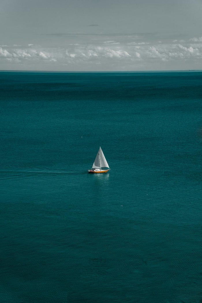 Small Sail in Vast Teal - Small sailboat surrounded by open teal sea. Museum-grade framed artwork by Veriando Studio.