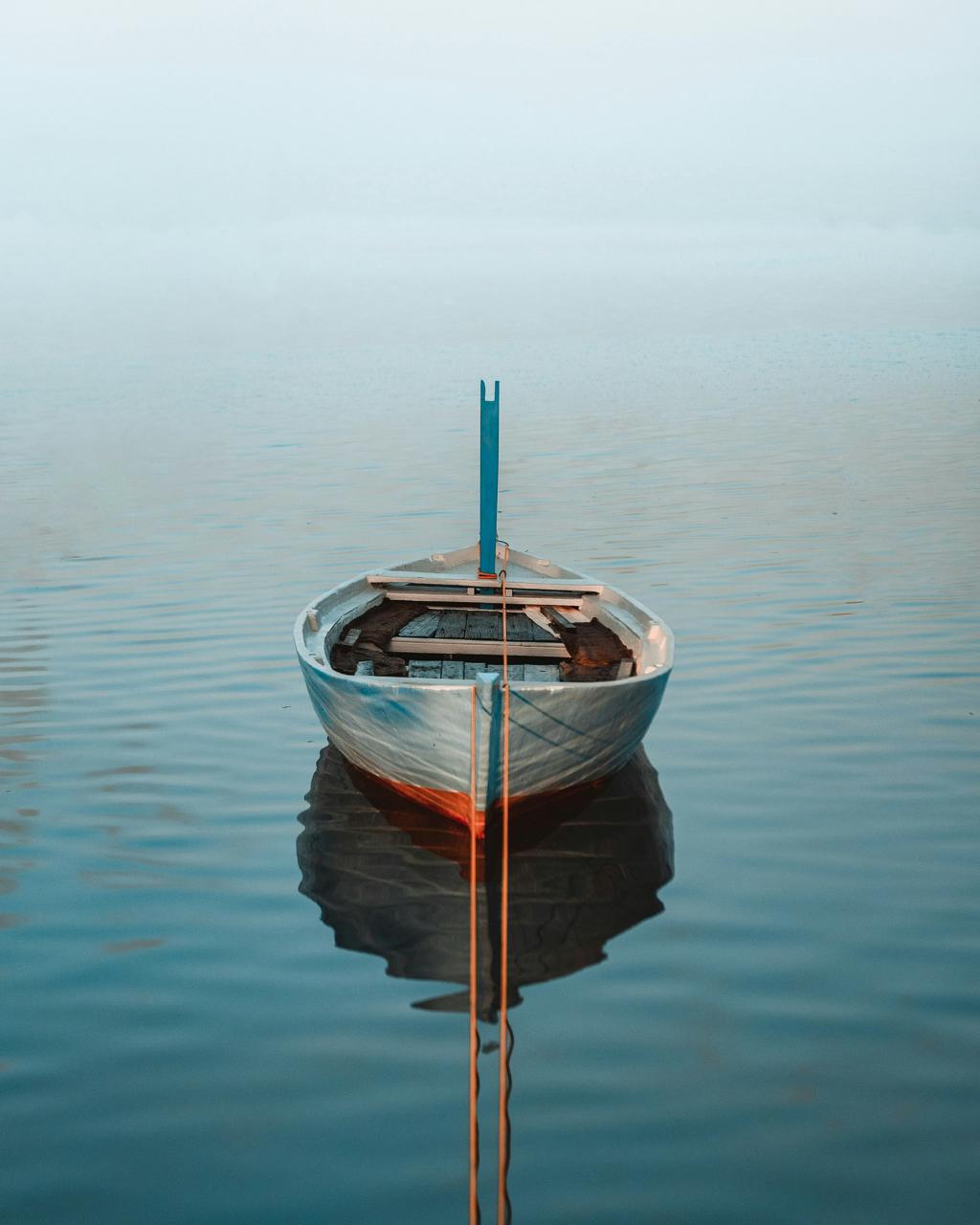 Still Boat in Pale Water - Small boat resting on still pale water. Museum-grade framed artwork by Veriando Studio.