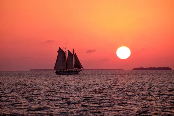 Sunset Sail and Crimson Sea - Sailboat crossing a red sunset sea. Museum-grade framed artwork by Veriando Studio.
